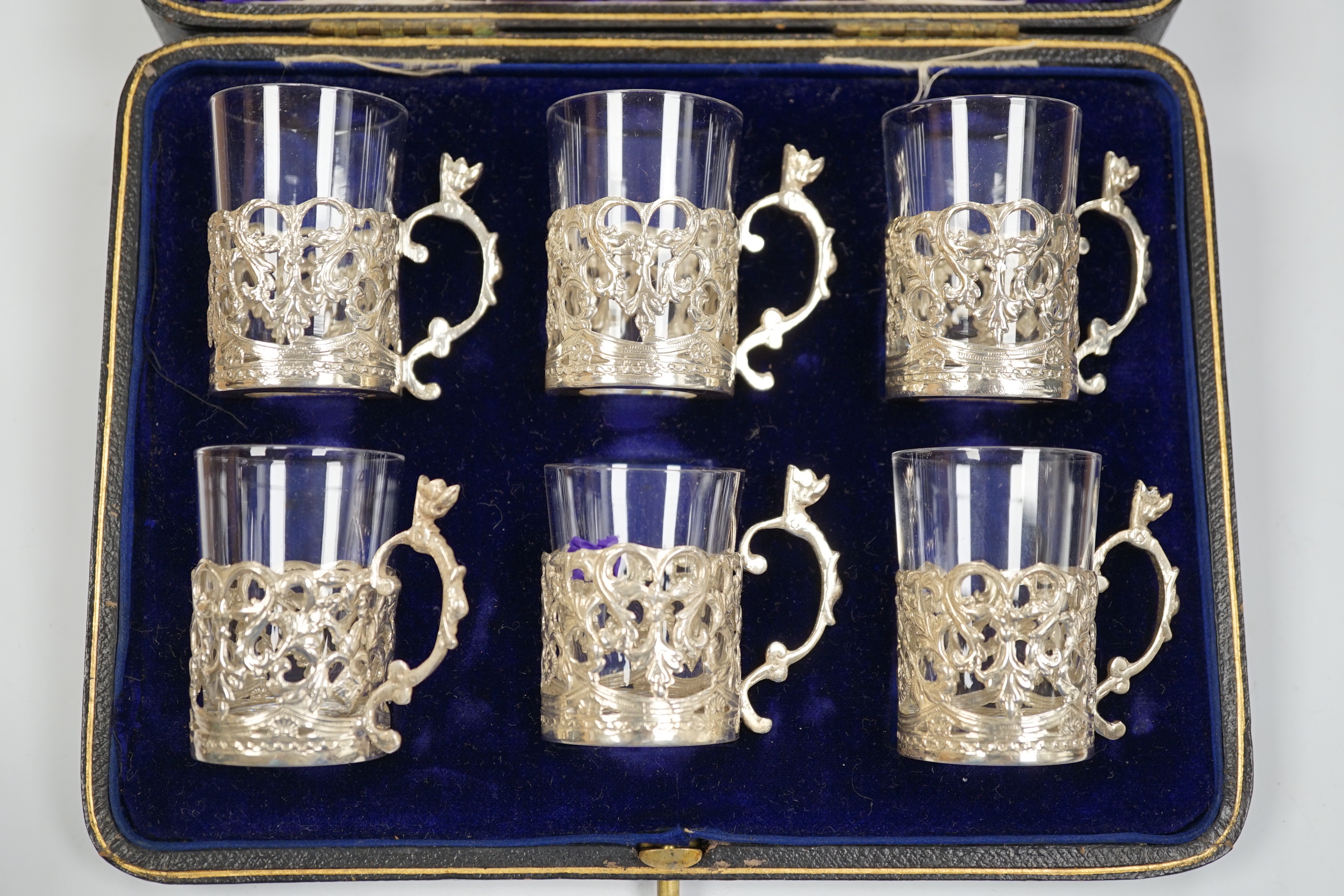 A George III engraved silver helmet shaped cream jug, Francis Purton?, London, circa 1790, height 10.6cm (a.f.), together with a cased set of six George V silver coffee can holders, with glass inserts, Marples & Co, Birm